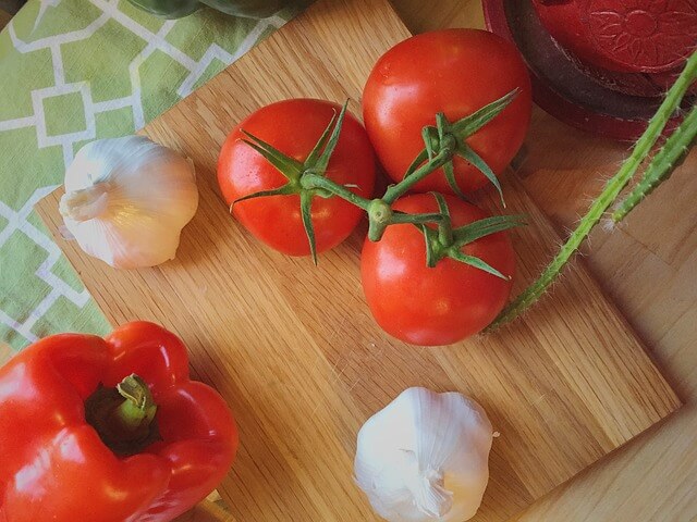 Pomidory i czosnek na drewnianej desce