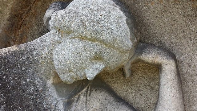 Starożytna rzeźba z pochyloną głową