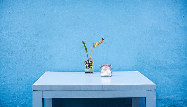 niebieski stolik na tle niebieskiej ściany